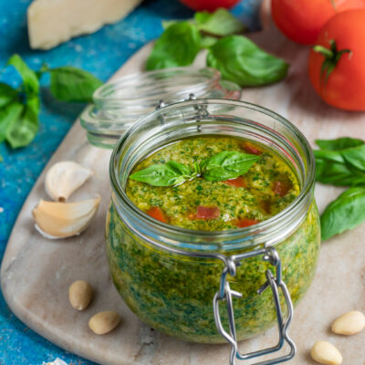 Pesto alla siciliana in barattolo di vetro con basilico fresco, pomodoro e pinoli