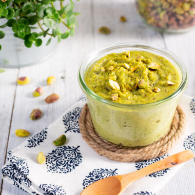 Pesto di pistacchi cremoso in vasetto, guarnito con pistacchi tritati in superficie