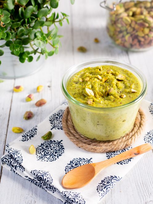 Pesto di pistacchi cremoso in vasetto, guarnito con pistacchi tritati in superficie