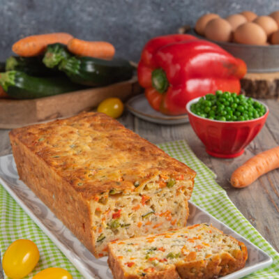 Torta salata con yogurt e verdure a fette, ripiena di zucchine, carote, piselli e peperoni