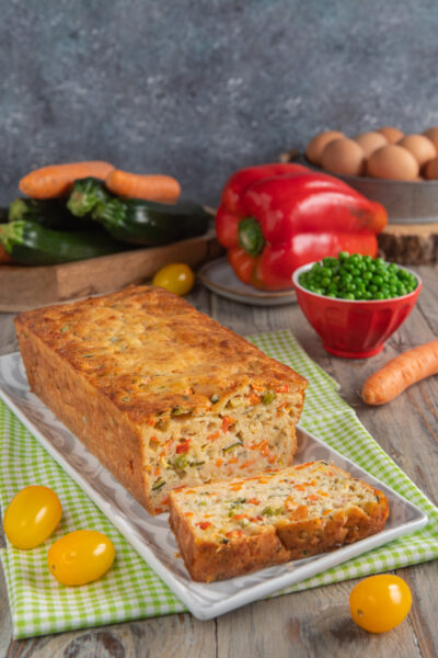 Torta salata con yogurt e verdure a fette, ripiena di zucchine, carote, piselli e peperoni