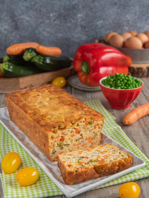 Torta salata con yogurt e verdure a fette, ripiena di zucchine, carote, piselli e peperoni