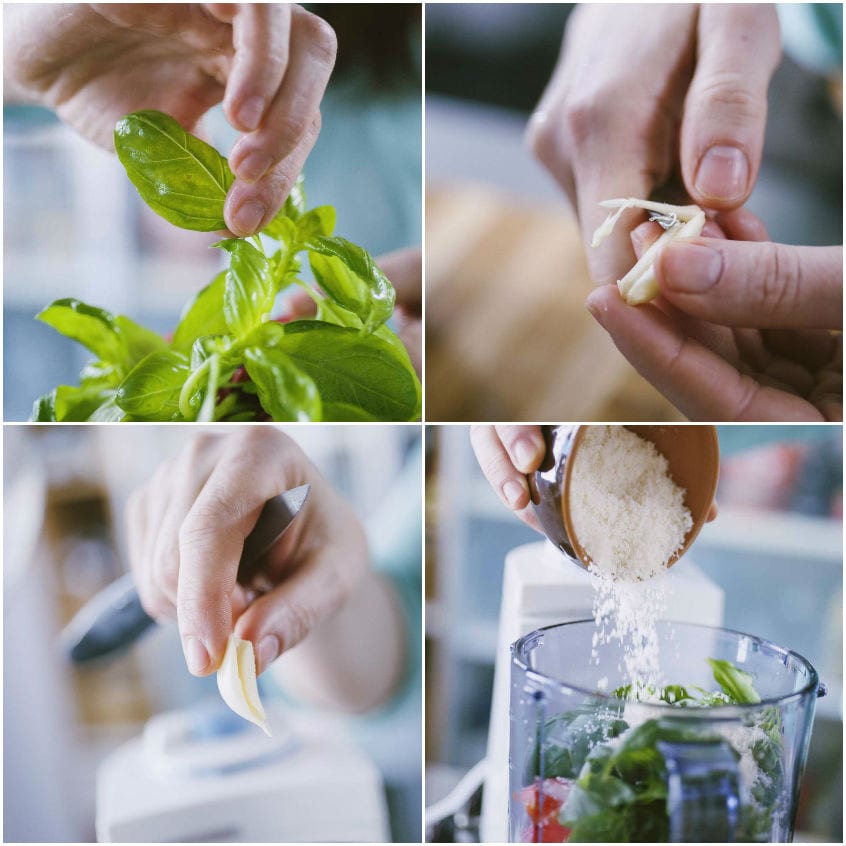 Foglie di basilico, aglio privato dell'anima e parmigiano grattugiato versato nel cutter per il pesto