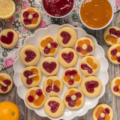 Biscotti primavera rotondi farciti con marmellata di lamponi e arancia a forma di cuore e fiore