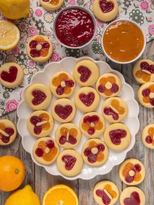 Biscotti primavera rotondi farciti con marmellata di lamponi e arancia a forma di cuore e fiore
