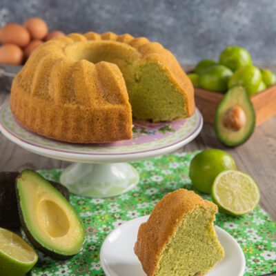 Ciambella all'avocado a fette con mollica verde chiara, servita con lime e avocado freschi