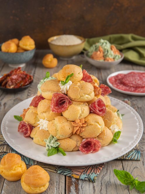 Profiterole salato a torre con bignè farciti, salame arrotolato e crema alle erbe