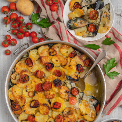 Riso patate e cozze gratinato con pomodorini arrosto e fette di patate dorate