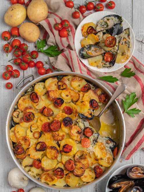 Riso patate e cozze gratinato con pomodorini arrosto e fette di patate dorate