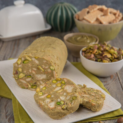 Salame al pistacchio affettato con pistacchi interi in vista e crema di pistacchio sullo sfondo