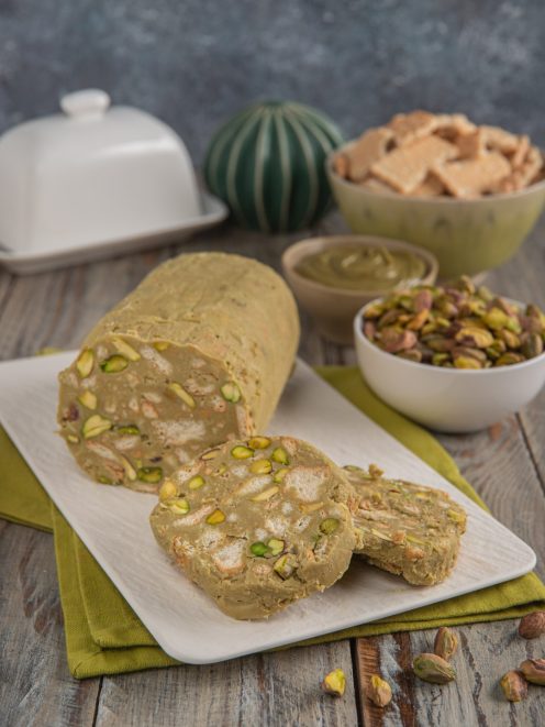 Salame al pistacchio affettato con pistacchi interi in vista e crema di pistacchio sullo sfondo