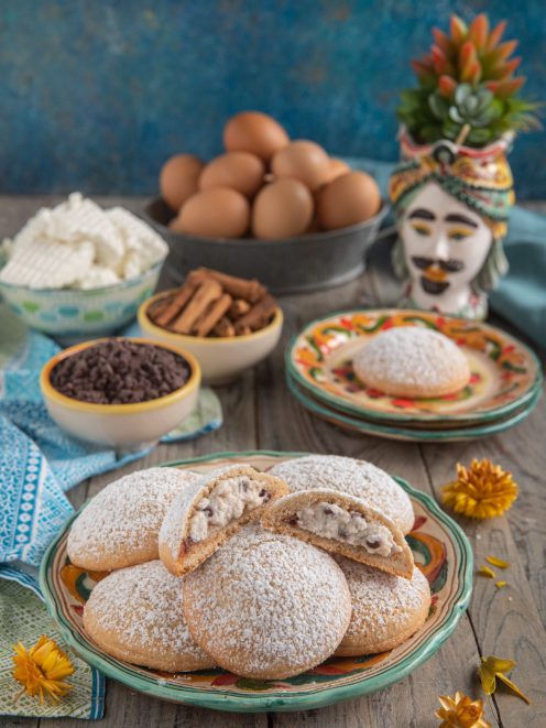 Spagnolette siciliane spolverate di zucchero a velo con cuore morbido alla ricotta e gocce di cioccolato