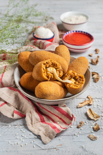 Supplì al telefono impanati e fritti, tagliati a metà con filo di mozzarella filante e ripieno di riso