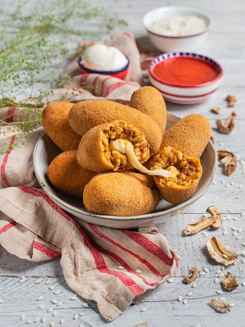Supplì al telefono impanati e fritti, tagliati a metà con filo di mozzarella filante e ripieno di riso