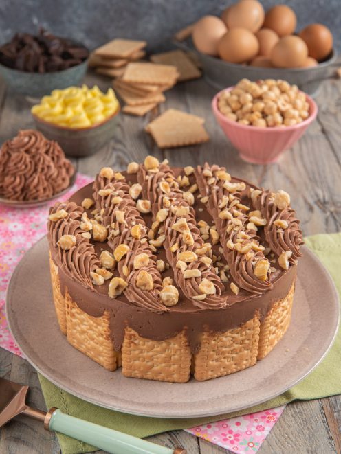 Torta fredda di biscotti secchi con bordo di frollini, crema al cioccolato e granella di nocciole
