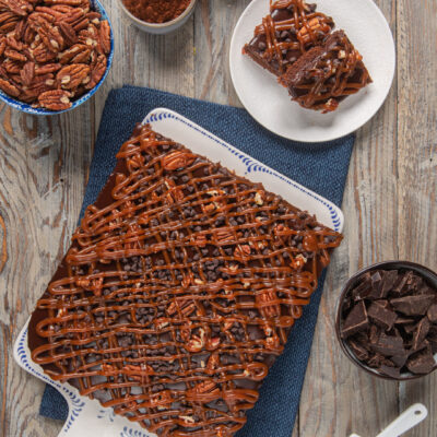 Torta texana al cioccolato con reticolo di caramello, gocce di cioccolato e noci pecan, tagliata a fette