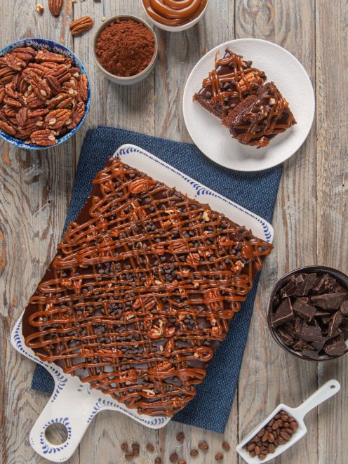 Torta texana al cioccolato con reticolo di caramello, gocce di cioccolato e noci pecan, tagliata a fette