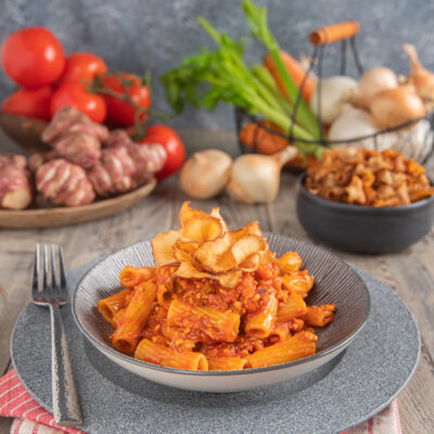 Tortiglioni con ragù di tofu al pomodoro, guarniti con chips croccanti di topinambur