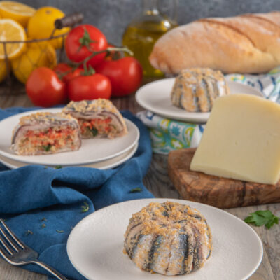 Tortino di alici alla siciliana con pangrattato dorato, ripieno di pomodoro e formaggio