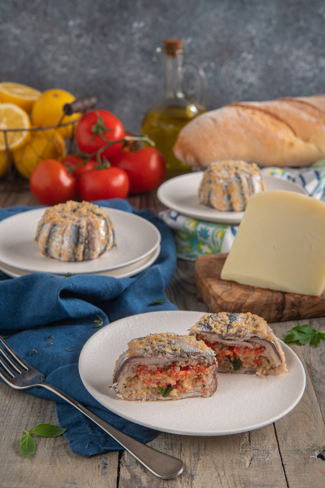 Tortino di alici alla siciliana tagliato a metà con ripieno di pomodoro e pangrattato ben visibile