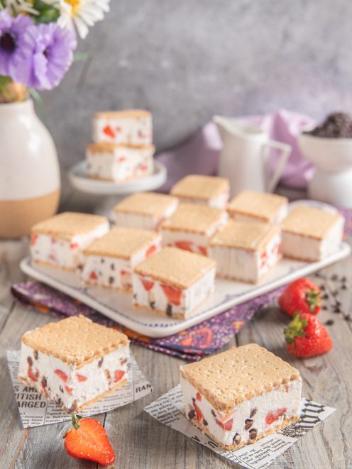 Biscotto gelato allo yogurt farcito con fragole e gocce di cioccolato, tagliato a quadrotti