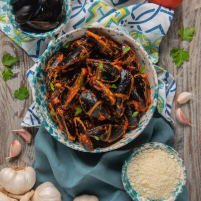 Cozze ripiene pugliesi al sugo di pomodoro, guarnite con prezzemolo fresco