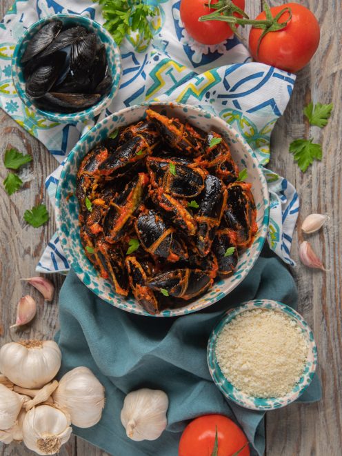 Cozze ripiene pugliesi al sugo di pomodoro, guarnite con prezzemolo fresco