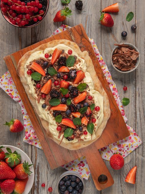 Pinsa romana dolce farcita con crema, fragole, mirtilli, more e scaglie di cioccolato