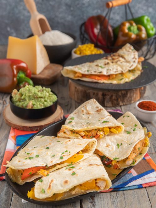 Quesadillas ripiene di pollo, peperoni e mais con guacamole e prezzemolo fresco