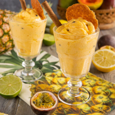 Sorbetto esotico alla frutta tropicale con cialde croccanti e cannella, servito in due coppe