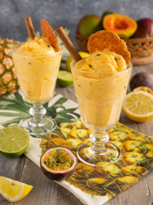 Sorbetto esotico alla frutta tropicale con cialde croccanti e cannella, servito in due coppe