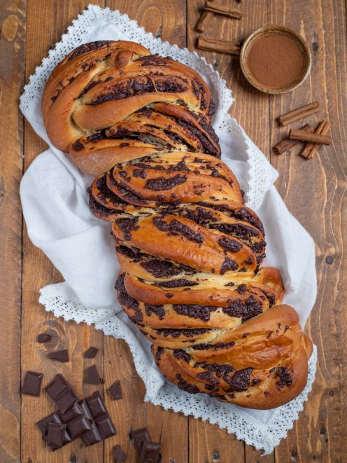 Babka intrecciata con ripieno di cioccolato fondente, dorata in superficie e ben sviluppata