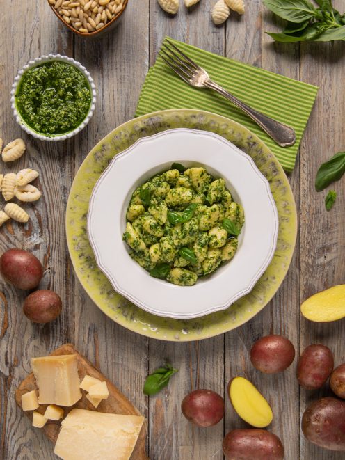 Gnocchi al pesto conditi generosamente con basilico fresco, serviti con parmigiano e pinoli