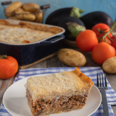 Fetta di moussaka con strati di carne macinata e besciamella gratinata in superficie