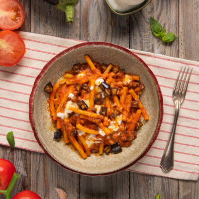 Pasta con melanzane e mozzarella in salsa di pomodoro con cubetti di melanzane fritte