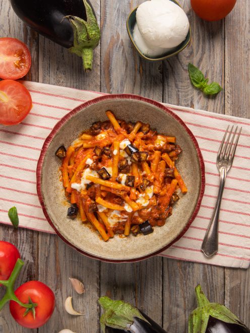 Pasta con melanzane e mozzarella in salsa di pomodoro con cubetti di melanzane fritte