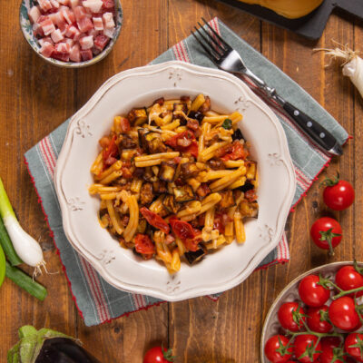 Pasta con melanzane e pancetta condita con pomodorini e filante provola affumicata