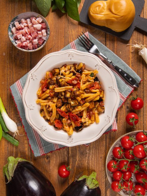 Pasta con melanzane e pancetta condita con pomodorini e filante provola affumicata