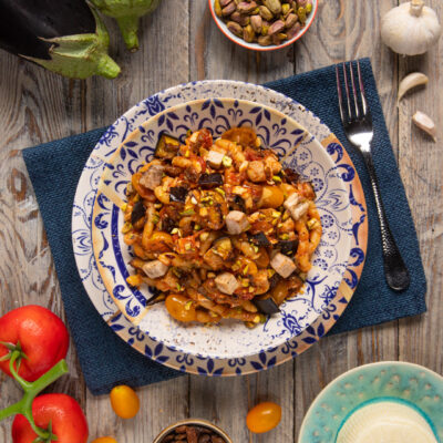 Pasta con pesce spada e melanzane condita con pomodorini, pistacchi tritati e uvetta