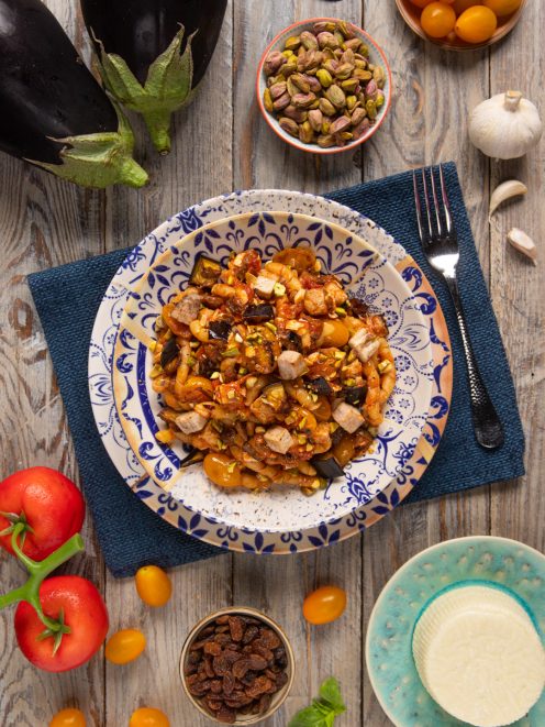 Pasta con pesce spada e melanzane condita con pomodorini, pistacchi tritati e uvetta