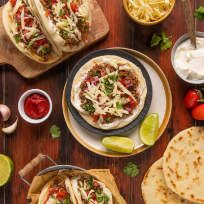 Tacos messicani di carne con pomodoro, cipolla rossa, formaggio grattugiato e coriandolo fresco
