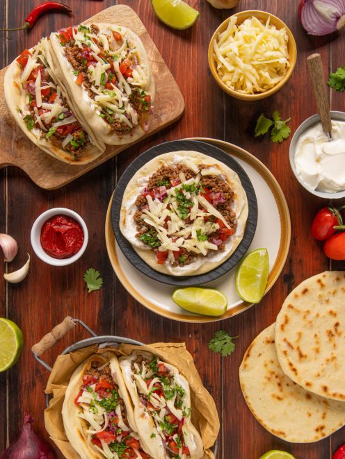 Tacos messicani di carne con pomodoro, cipolla rossa, formaggio grattugiato e coriandolo fresco