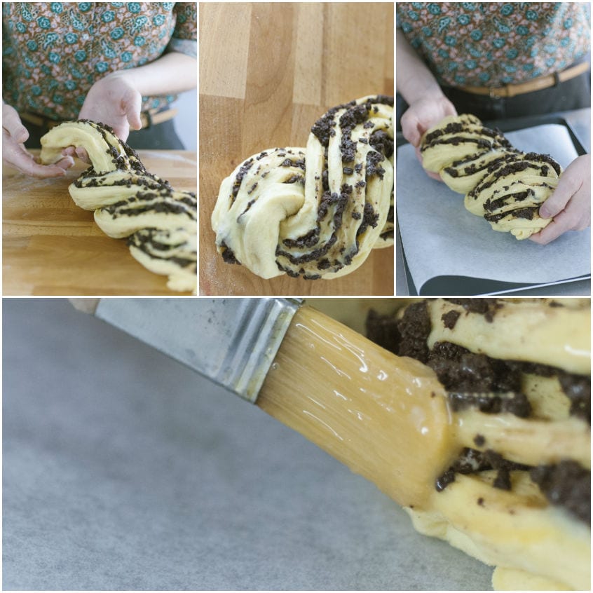 Mani che intrecciano la babka farcita al cioccolato, poi spennellata con uovo sbattuto