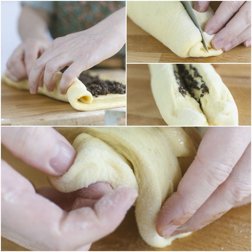 Mani che arrotolano l'impasto farcito al cioccolato e lo tagliano a metà per intrecciare la babka