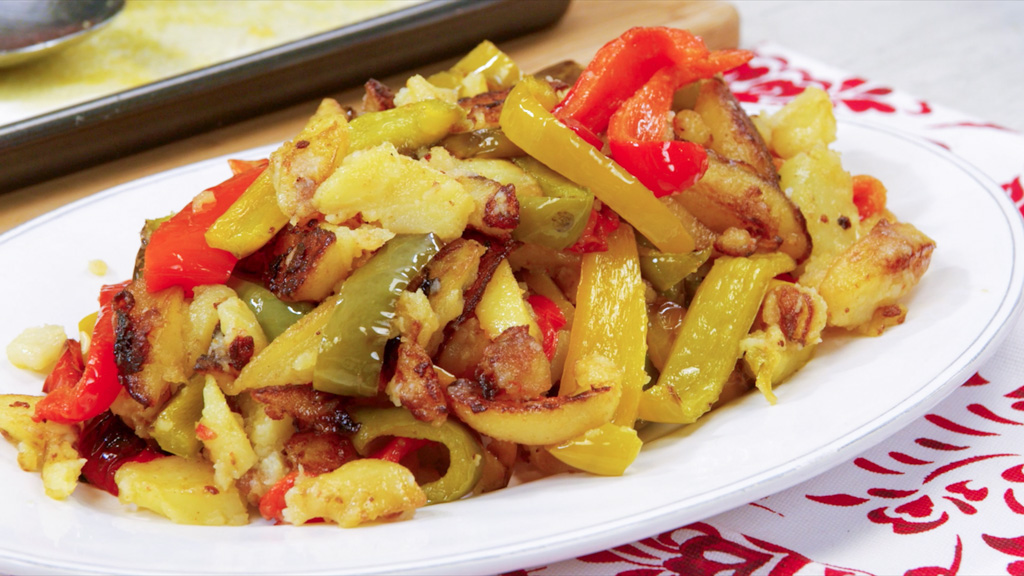 Peperoni e patate lucidi e cedevoli con bordi bruciacchiati in padella