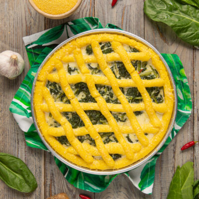 Crostata di polenta con erbette ripiena e grata dorata a intreccio in teglia
