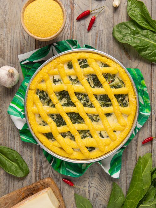 Crostata di polenta con erbette ripiena e grata dorata a intreccio in teglia