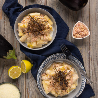 Rigatoni cacio e limone con tonno e melanzane croccanti serviti in due ciotole con scorza grattugiata