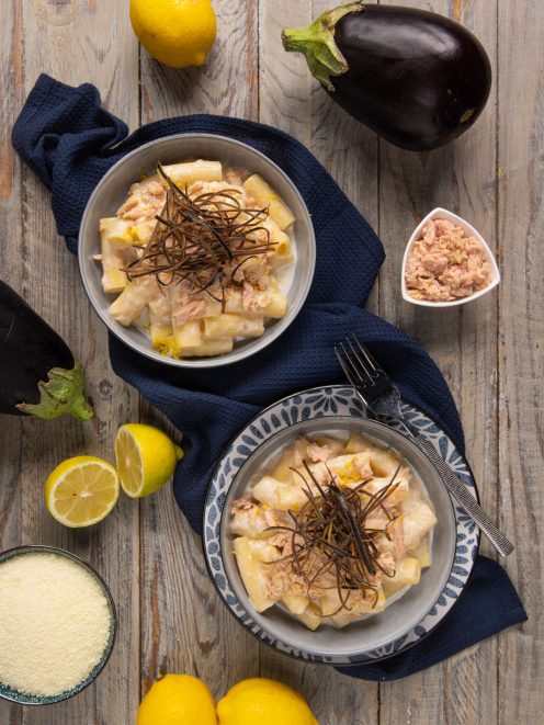 Rigatoni cacio e limone con tonno e melanzane croccanti serviti in due ciotole con scorza grattugiata
