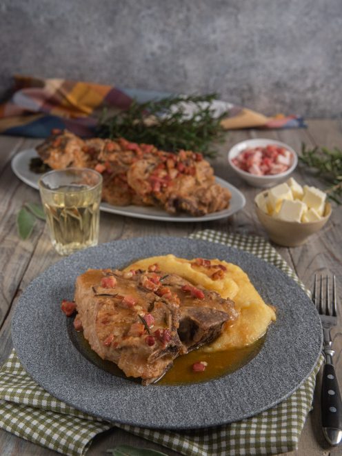 Roastin negaa con polenta gialla, cotenna di maiale e pancetta a dadini nel sugo